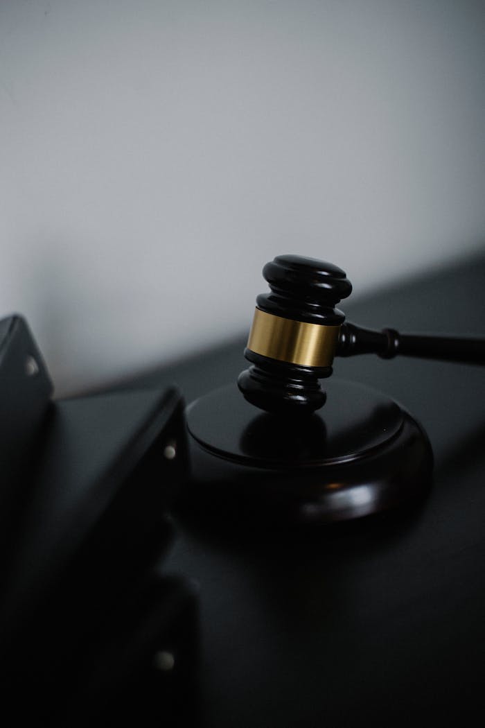 services-04 Black wooden gavel with golden strip on table near stack of folders in courthouse